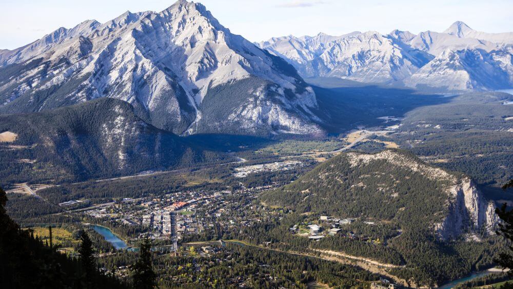 banff gondola looking down ontop the town during the day with cascade mountain in the background