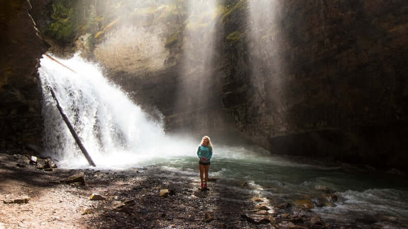 Secret spot at johnston canyon with beams of light coming through the trees