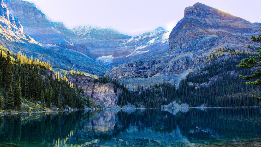 lake ohare close to lake louise glare off lake mountain peaks gallery pics