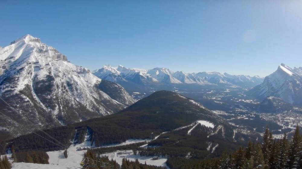 top of mount norquay ski hill looking down to banff mountain range